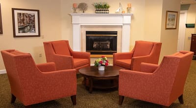 Common area with orange chairs around a coffee table