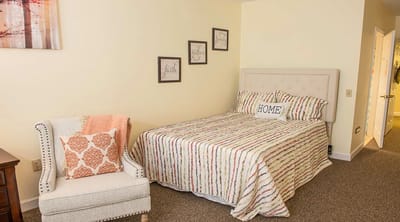 Cozy resident room with a bed and armchair