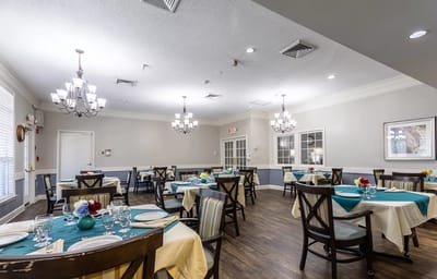 Dining room setup with tables and chandeliers