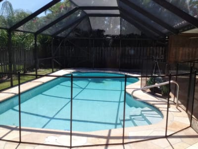 Outdoor swimming pool surrounded by screen enclosure