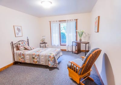 A private resident room with a bed and seating area