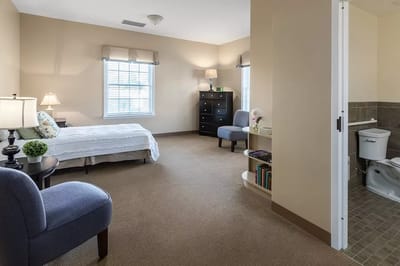 A private resident room with a bed and sitting area