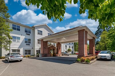 Exterior view of the facility entrance with canopy and parking