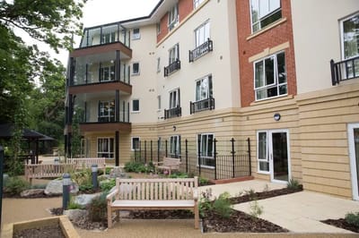 Exterior view of the facility with gardens and benches
