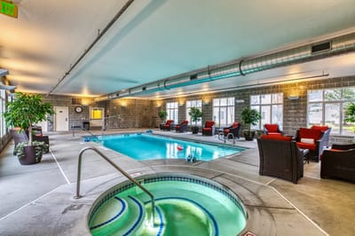 Indoor pool area with seating and plants.