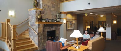 Residents chatting in a cozy common area with a fireplace