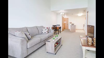 Bright interior of a resident room with a couch and dining area