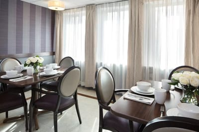Bright dining room with tables set for meals