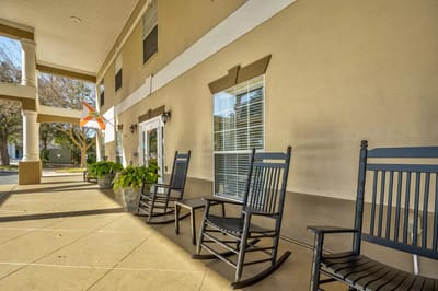 Front porch area with rocking chairs and potted plants