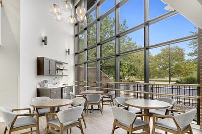 Bright common area with large windows and furniture