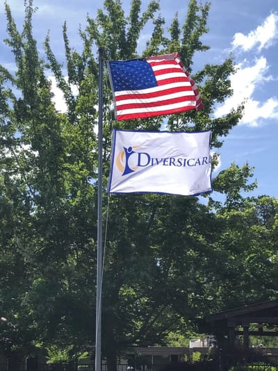 Flagpole displaying the Diversicare logo and American flag