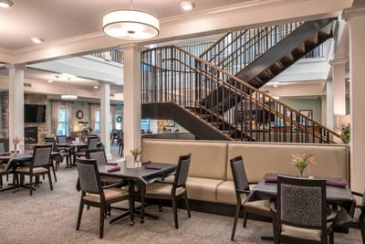 Dining area with tables and a staircase in the background
