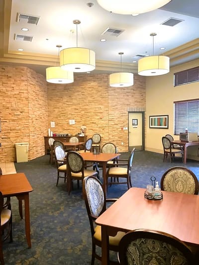 Dining area with tables and chairs in a senior living facility