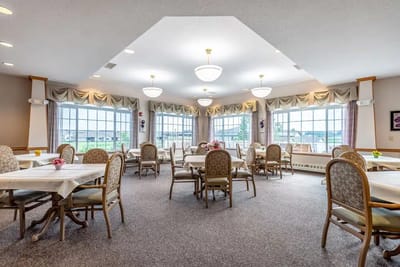 Bright dining room with tables and chairs arranged for residents