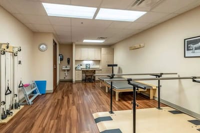 Physical therapy room with equipment and wood flooring