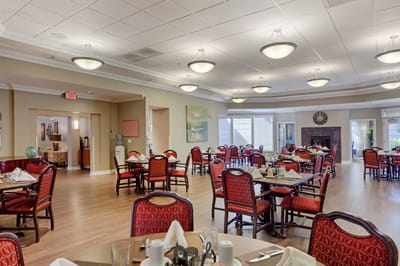 Bright dining room with red chairs and tables set up