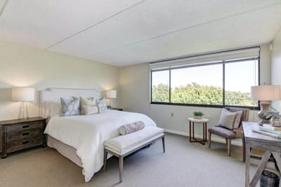 A bright and inviting resident room with a bed and seating