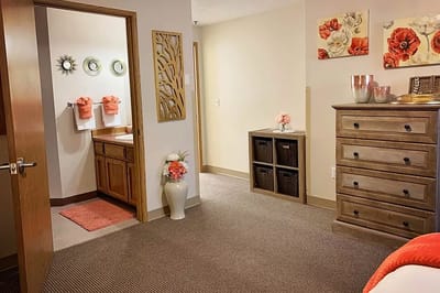 A cozy resident room with floral decor and a bathroom