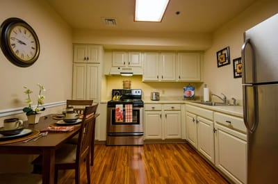 A well-lit kitchen area with dining table and appliances