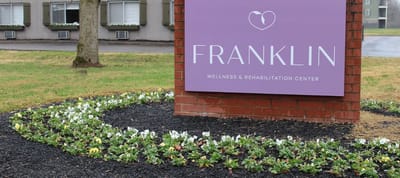 Facility logo sign with flowers in front