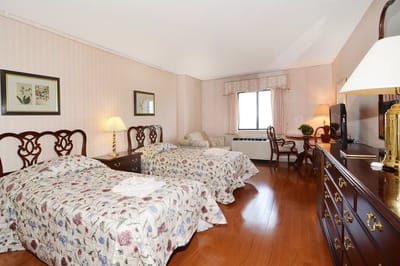 A cozy resident room with two beds and a window