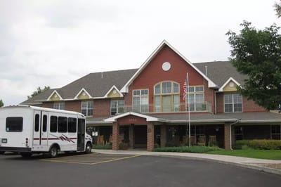 Exterior view of the assisted living facility with a shuttle bus
