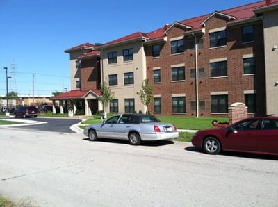 Exterior view of a senior living facility with vehicles
