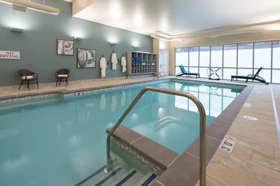 Indoor swimming pool area with seating and no diving sign