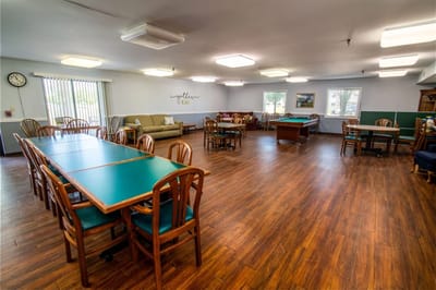Common area with tables and chairs in a senior living facility