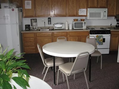 A kitchen area with a round table and chairs