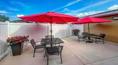 Outdoor patio area with red umbrellas and seating