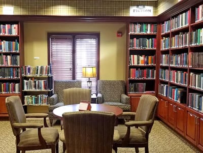 Interior view of a cozy library with bookshelves and seating