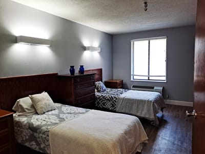 A cozy resident room with two beds and natural lighting