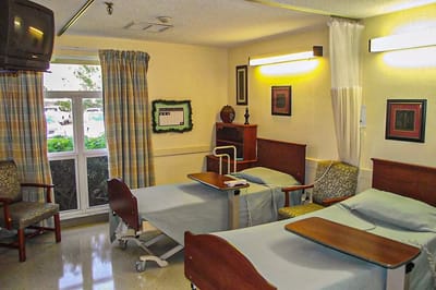 Interior view of a shared resident room with beds and TV