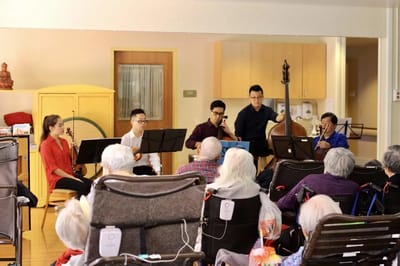 Residents enjoying a musical performance in a common area