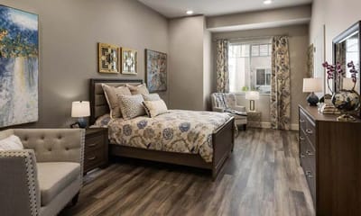 Brightly decorated resident room with a bed and seating area