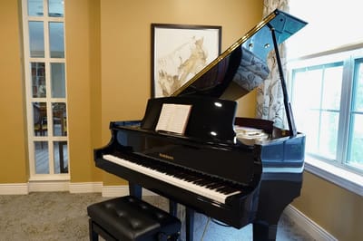 A grand piano in a well-lit common area.