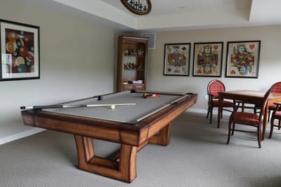 A game room with a pool table and artwork