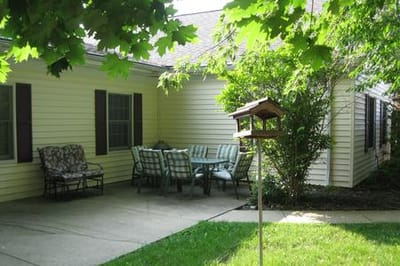 Quaint outdoor seating area with chairs and birdhouse