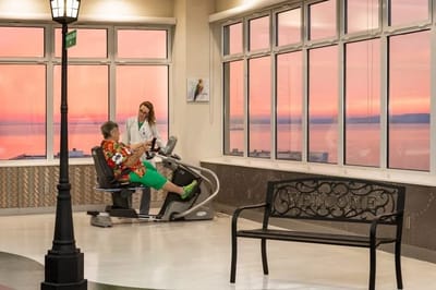 A resident exercising with staff assistance in a bright indoor space