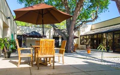 Outdoor seating area with wooden furniture and umbrella