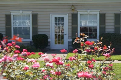 Front entrance of a facility surrounded by flowers