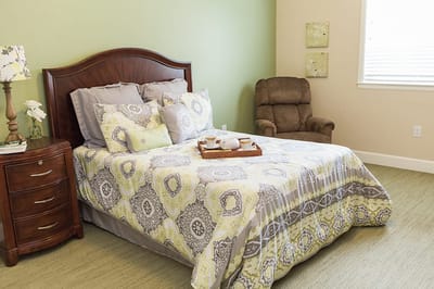 A furnished private bedroom with a cozy bed and decor