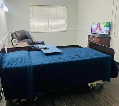 A private resident room with a bed and chair