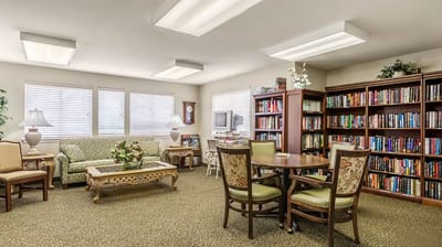 A cozy indoor common area with seating and bookshelves