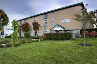Exterior view of Holiday Retirement Community with green landscaping