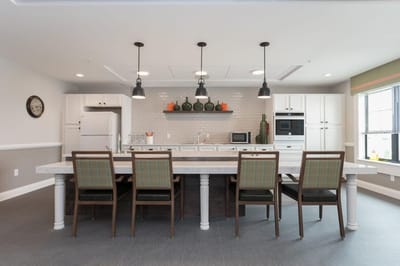 Modern dining area with a long table and kitchen appliances