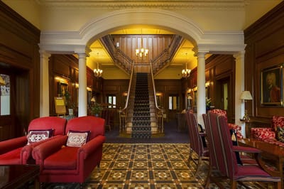 Elegant interior lobby with red chairs and a grand staircase