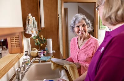 Resident and staff member interacting in the kitchen