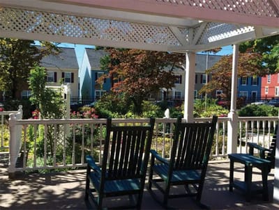 Seating area in a garden with colorful buildings in the background